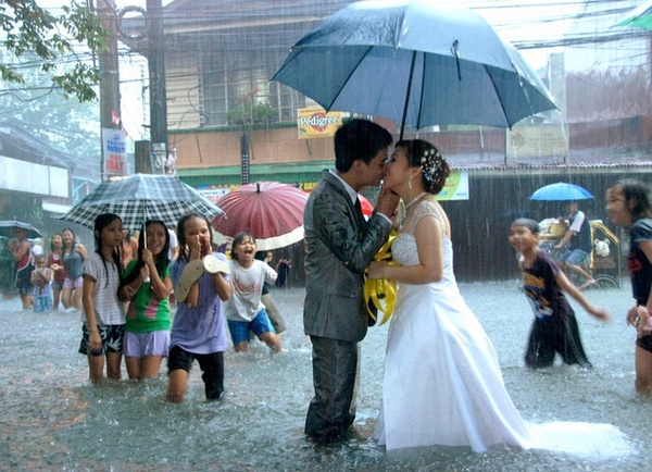 Đôi uyên ương trao nhau nụ hôn ngọt ngào giữa con đường ngập nước và mùa mưa bão ở Manila, Philipines.